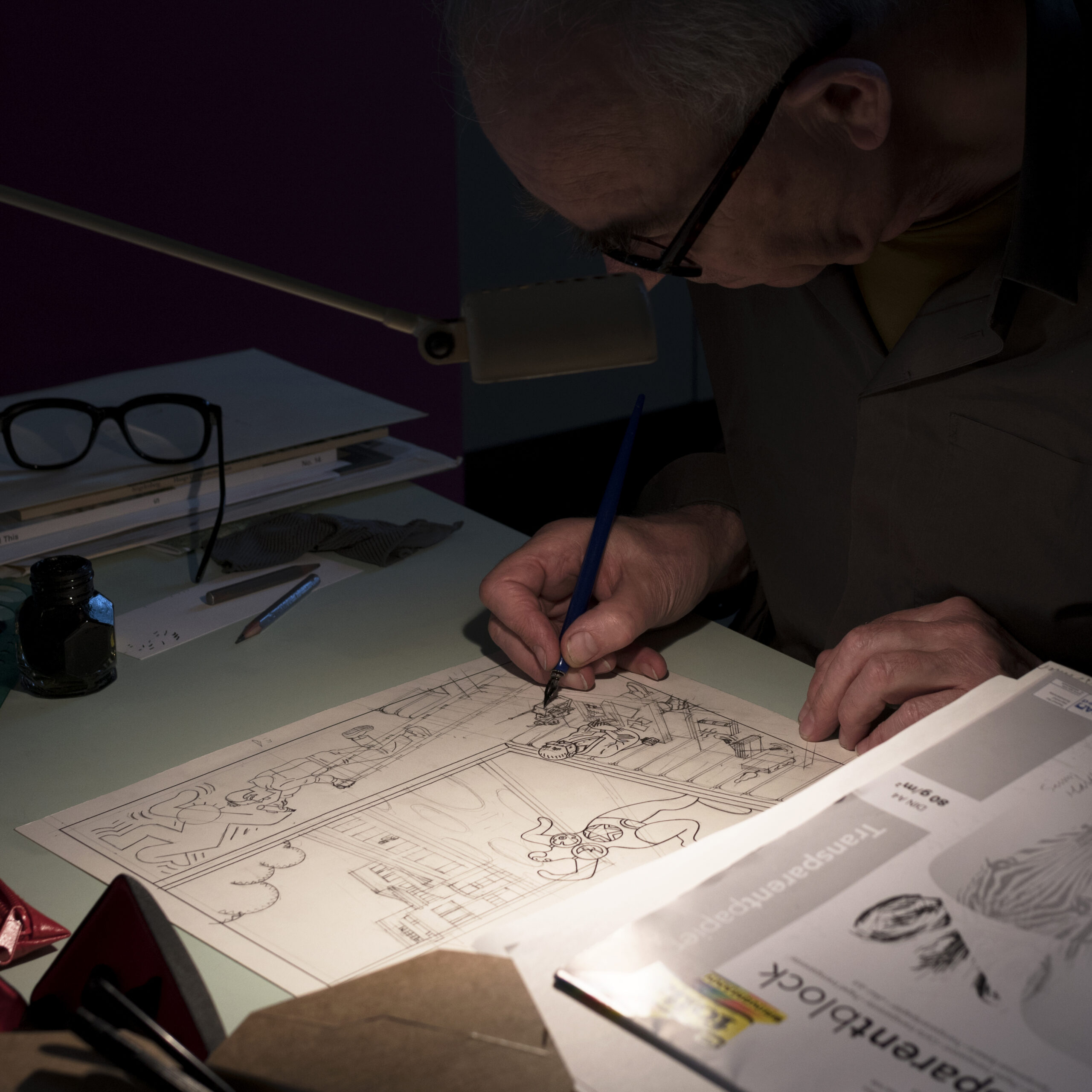 een striptekenaar in zijn atelier